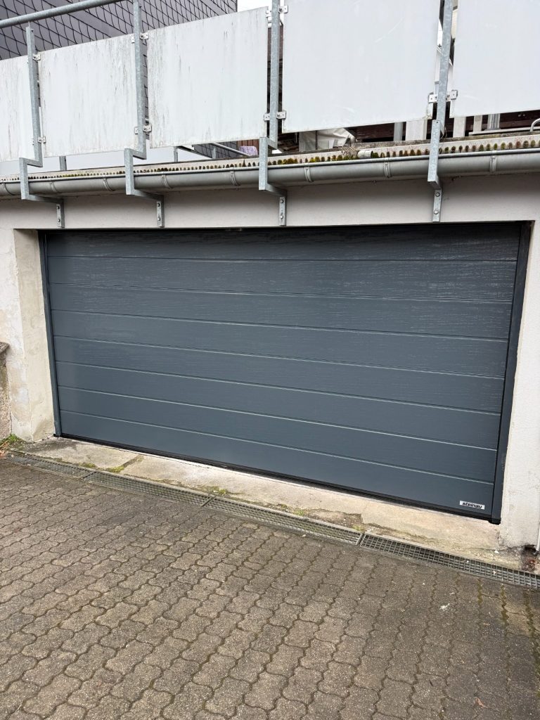 Neues Sektionaltor M-Sicke Woodgrain RAL 7016 Anthrazitgrau Zarge in Torfarbe. Antrieb mit Smart Home